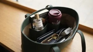 A sleek, spill-proof everyday fragrance bottle nestled securely in a daily tote bag, ideal for busy commutes on the London Underground.